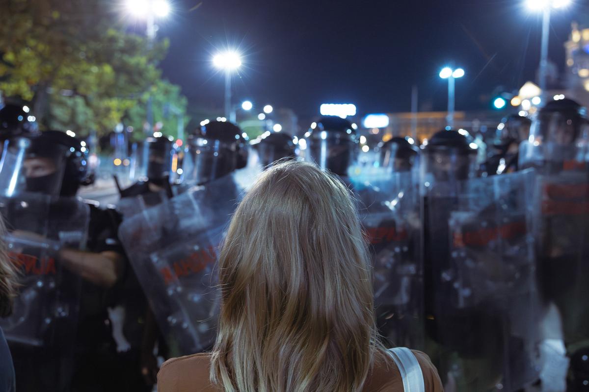 Žena stoji sama ispred policijskog kordona tokom protesta u Srbiji